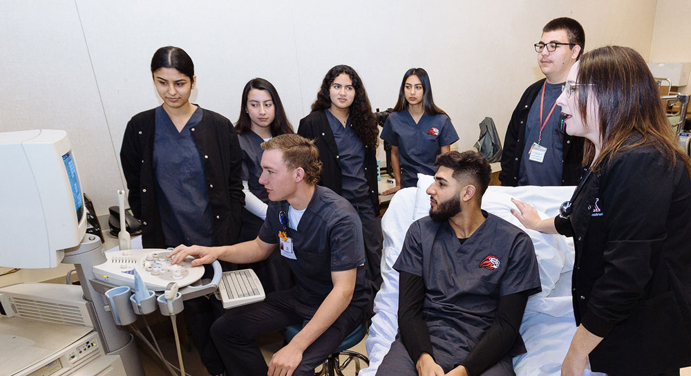 About 8 students observe a monitor 