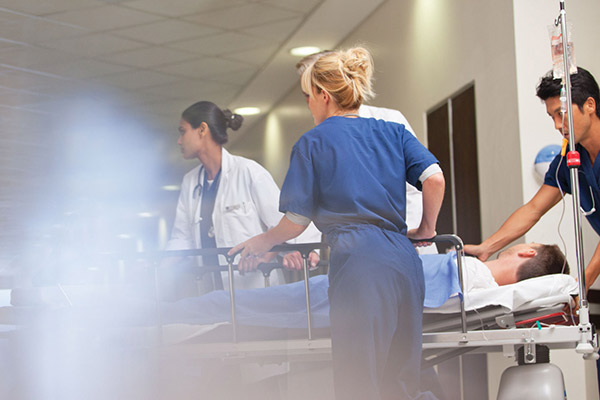 A trauma team wheels a patient through a hospital corridor