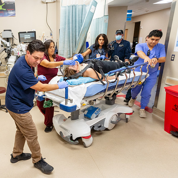 A group of responders tend to a trauma patient on a gurney