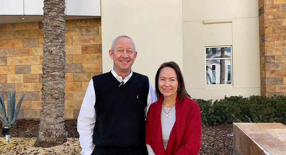 A man and a woman stand outside of a building