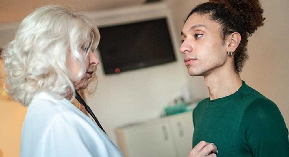 Doctor holds a stethoscope to a patient's chest