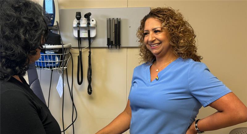 A healthcare worker smiles at a patient in a clinical setting