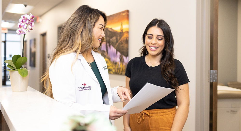A doctor and a woman confer in a hallway