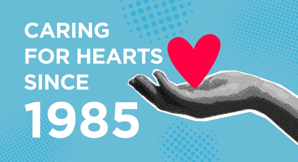 Caring for Hearts since 1985: a hand holds a cartoon heart