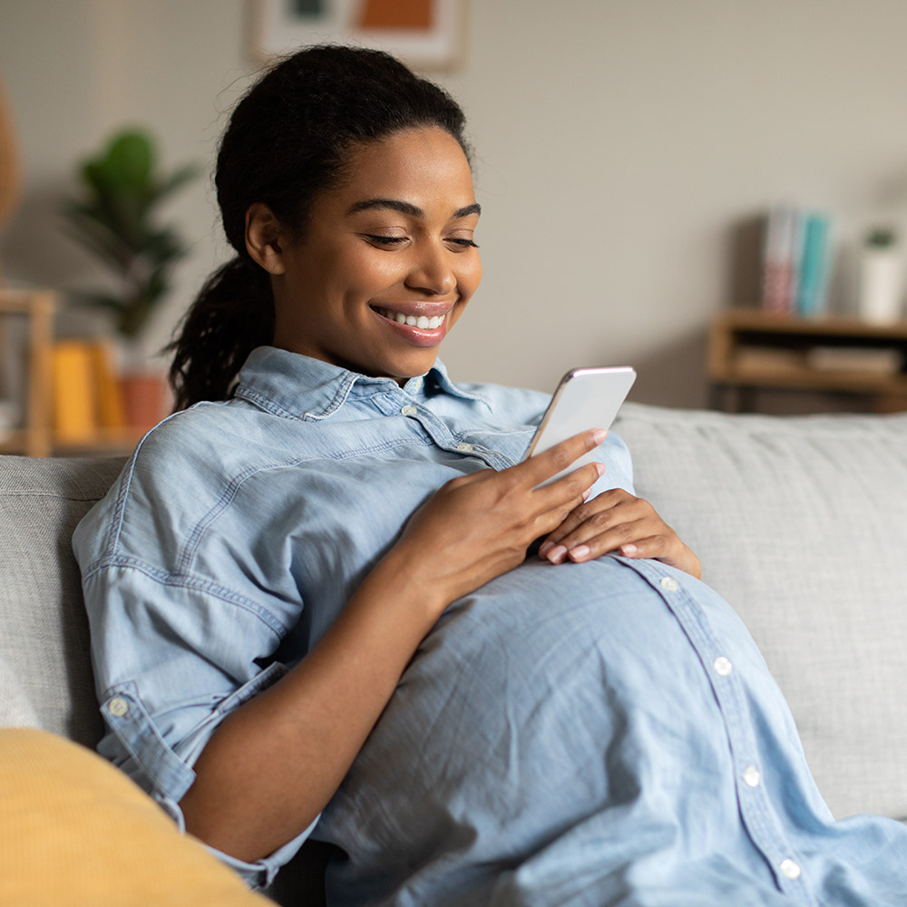 Pregnant woman looks at phone