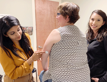 UCSF Fresno’s Varsha Babu, MD, helps Annette Simmons test her glucose levels with a shot in the back of the arm.