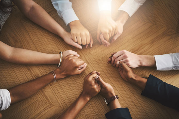 A circle of hands as people sit in a group