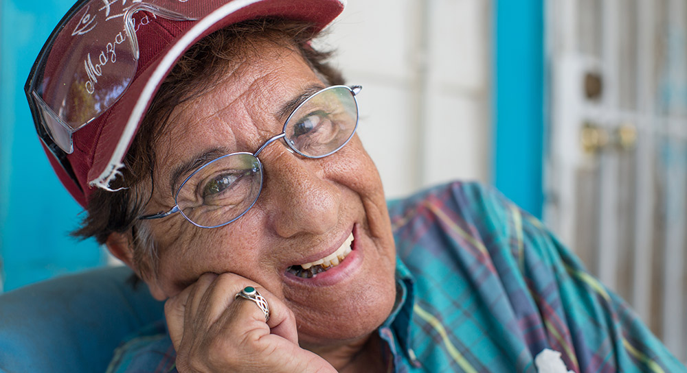 A close-up image of 67-year-old Barbara Hernandez wearing a maroon ball cap