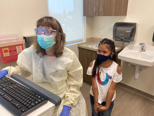 Dr. Renee Kinman works on a computer as Kailee Sidamrong-Phan looks on