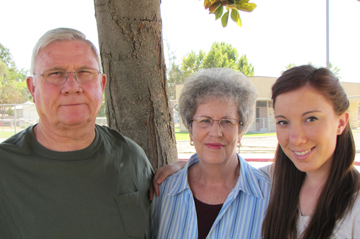 A white man, white woman and younger white woman look at the camera