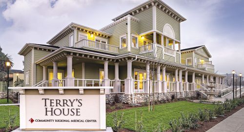 Exterior of a two-story house with a sign reading "Terry's House" in front of the buidling