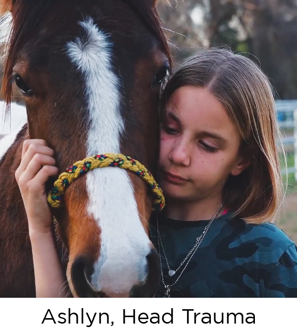 A young girl with dark blond hair, rests her face against the head of a brown horse