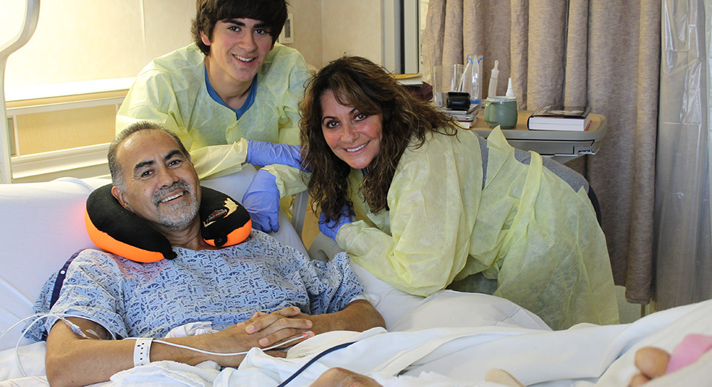 Three members of the Villareal family are shown. Arthur is in his hospital bed surrounded by wife Karen and a teen boy.