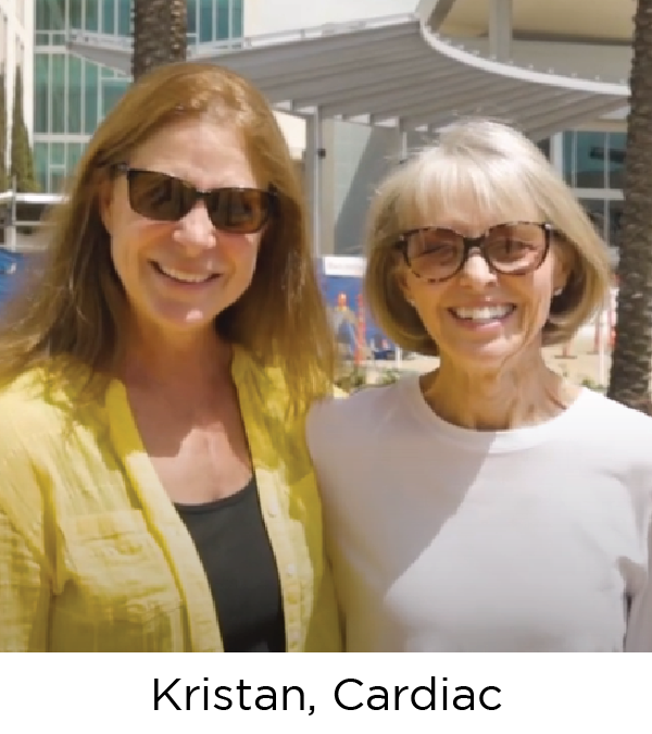 Two women, both white and wearing sunglasses, smile at the camera