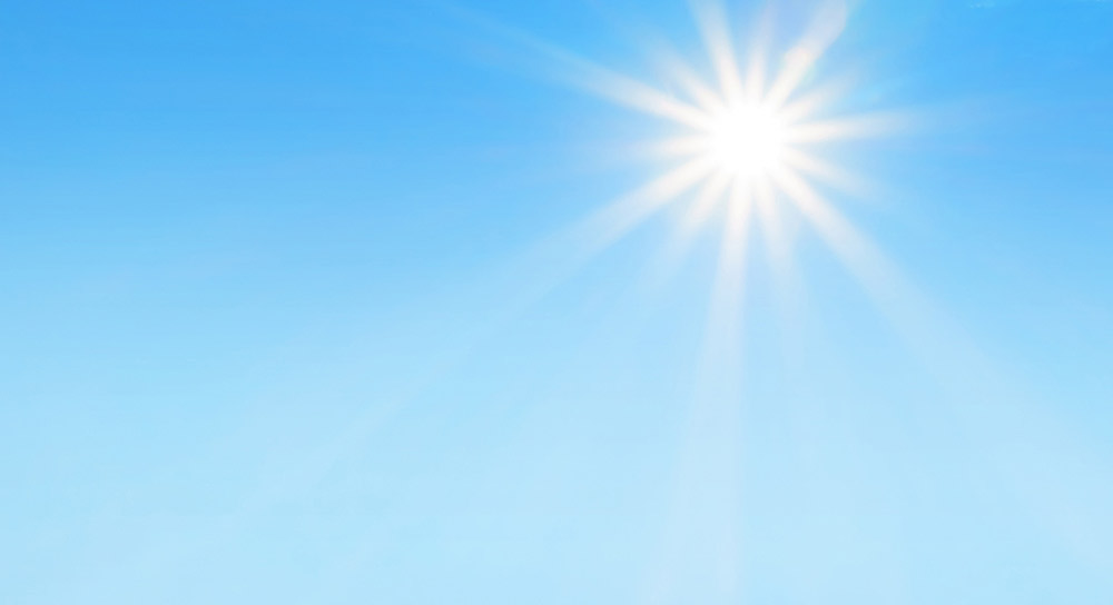 A light blue sky with the sun shining brightly 