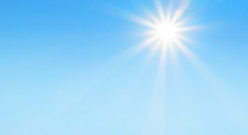 A light blue sky with the sun shining brightly 