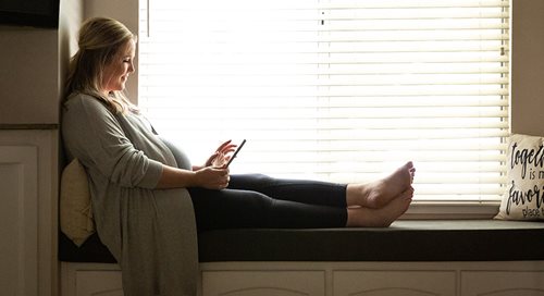 Pregnant woman looks at her cellphone