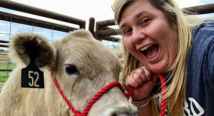 Mindy Calisso poses with light-colored cow